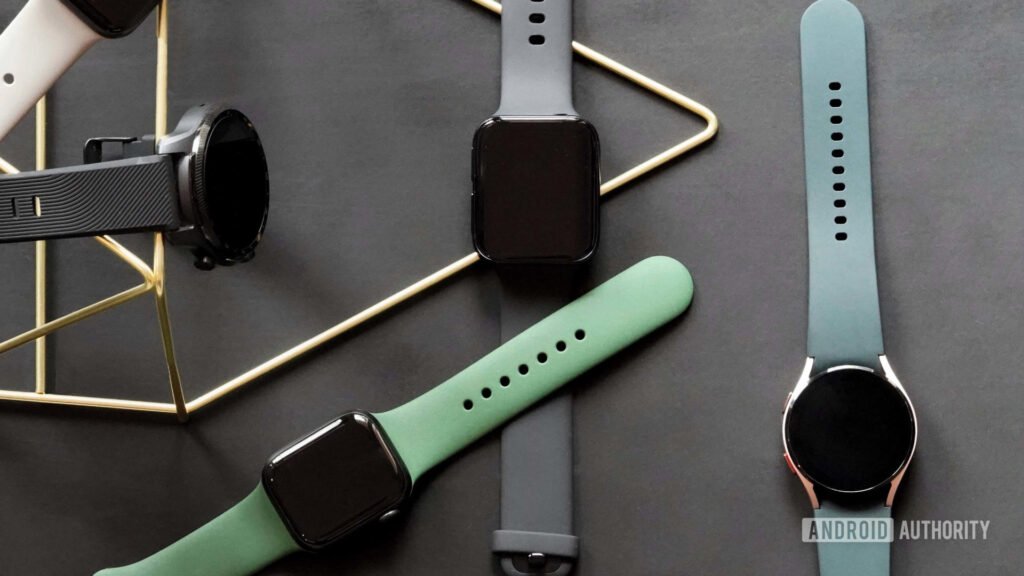 A mix of Wear OS and Apple Watches rest on a black rubber mat, illustrating a mix of square and circular watch options.